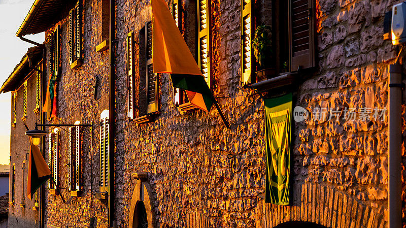 在翁布里亚(Umbria)的中世纪小镇瓜尔多·塔迪诺(Gualdo Tadino)，落日的余晖温暖着石墙